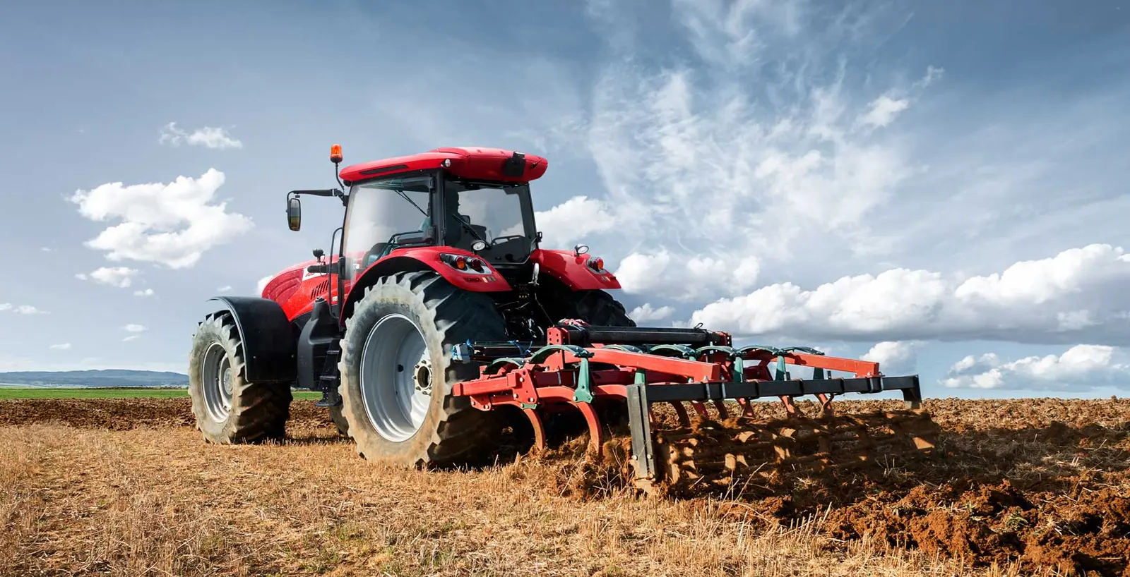 Tractor carrying out deep soil cultivation with a ripper